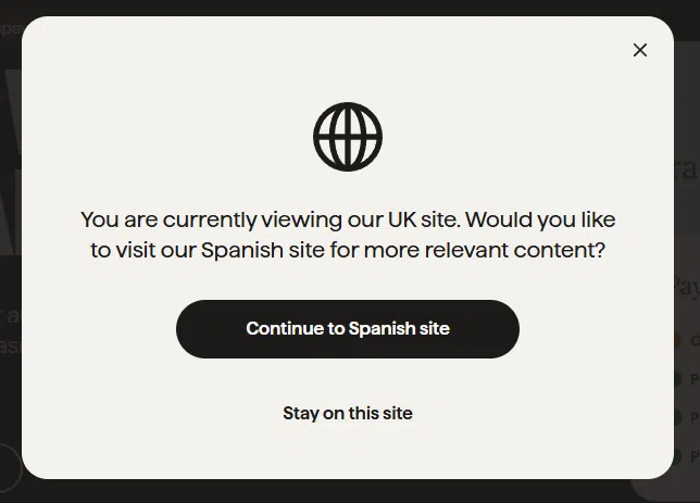 Ventana modal que pregunta al usuario si desea cambiar del sitio en inglés al sitio en español, con opciones para continuar o permanecer en el sitio actual.